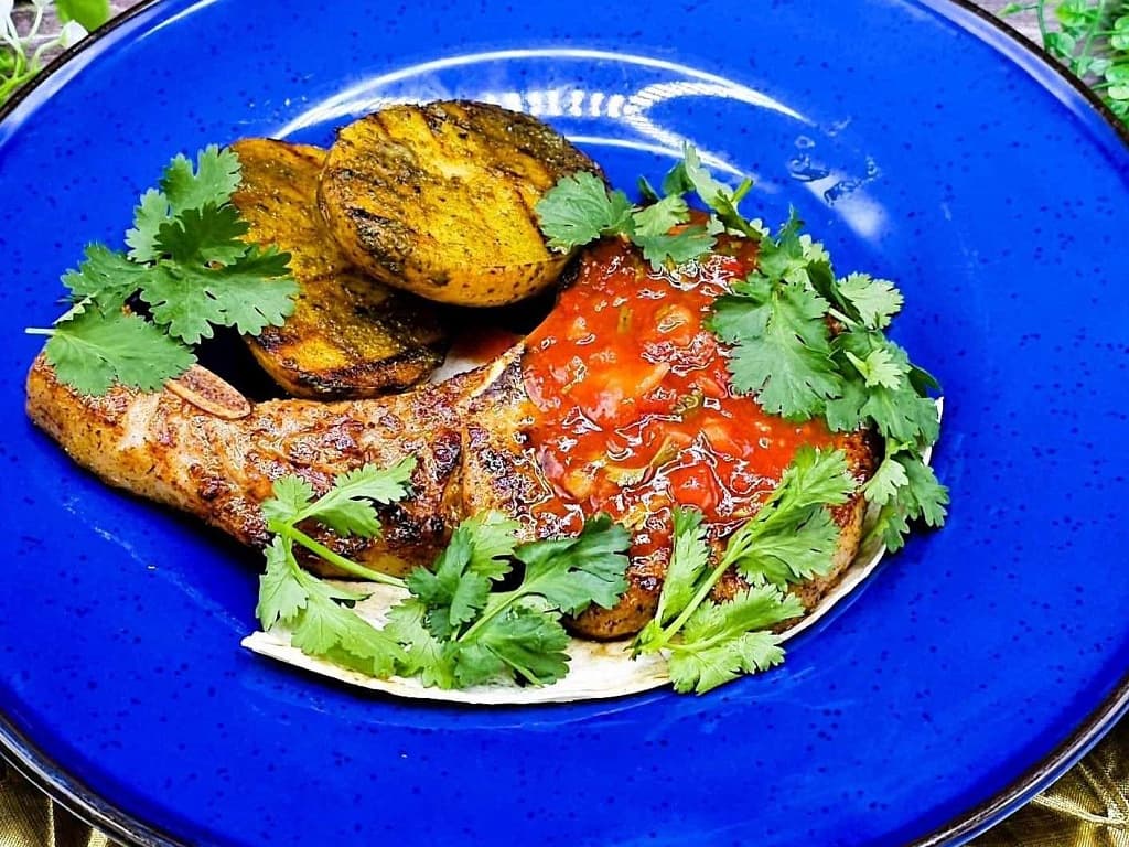 Cowboy pork steak with baked potatoes in charcoal and salsa sauce