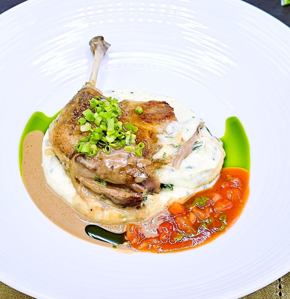 Duck leg confit with mashed potatoes and herbs