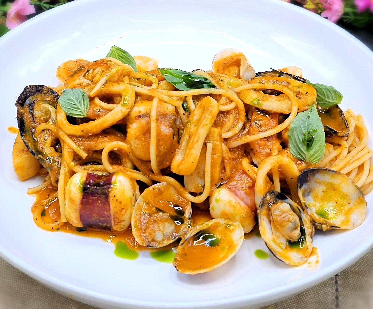 Spaghetti with cheese in tomato sauce and basil oil