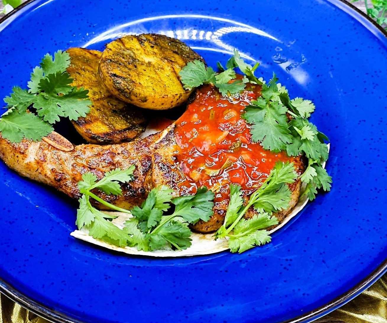 Cowboy pork steak with baked potatoes in charcoal and salsa sauce